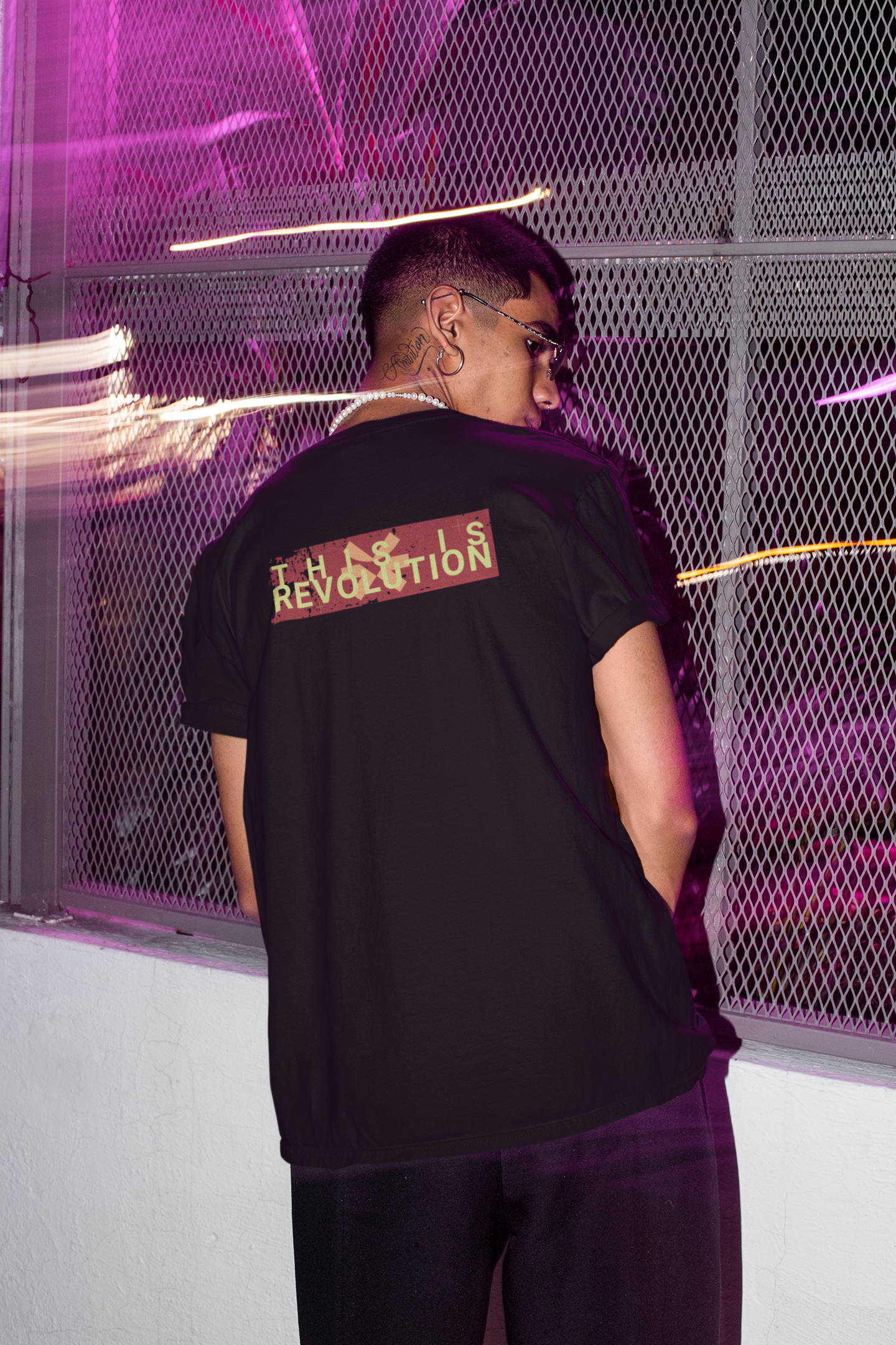 Person wearing a black t-shirt with text on the back in a futuristic setting.