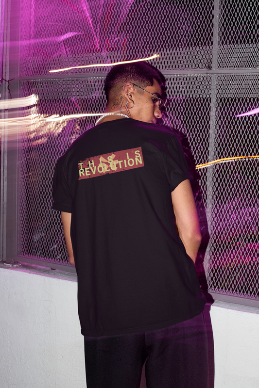 Person wearing a black t-shirt with text on the back in a futuristic setting.