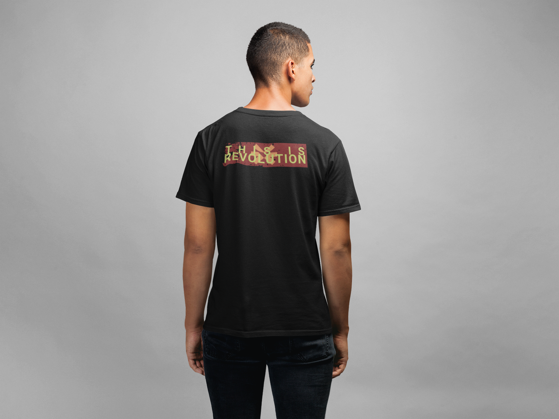 Person wearing a black t-shirt with text on the back against a gray background