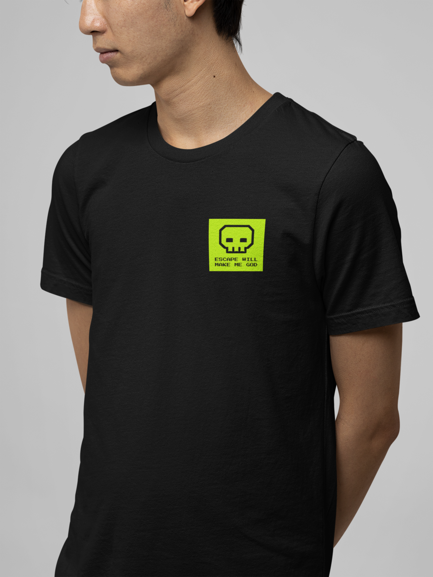 Person wearing a black t-shirt with a yellow logo on a gray background